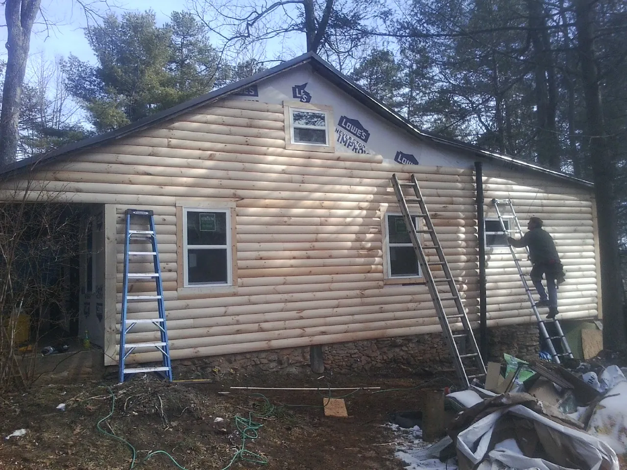 Ladders set against fresh log siding during an exterior remodel in Morrisville
